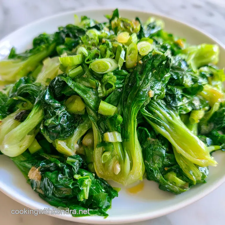 Neatly arranged saut&eacute;ed greens with a glossy glaze on a minimalist white ceramic plate topped with sesame seeds.