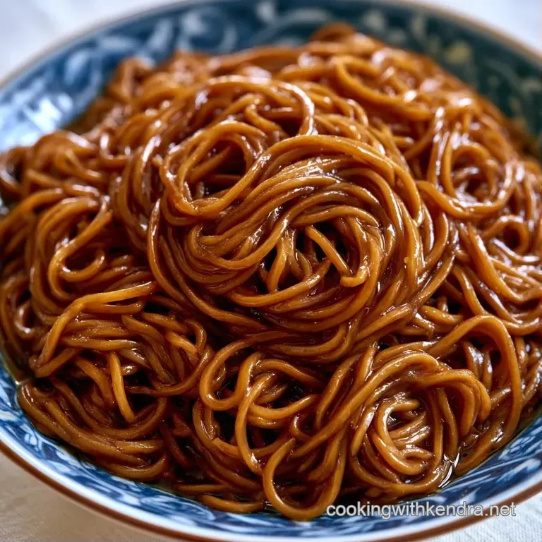 Earthy buckwheat noodles swirled in a ceramic bowl, garnished with vibrant green onions and a drizzle of soy sauce.